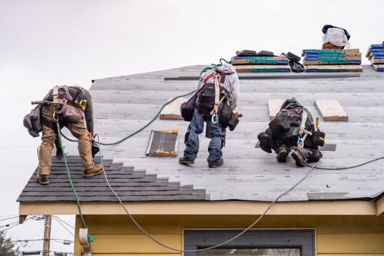 Professional roofing crew in safety harnesses installing GAF Landmark architectural shingles on a residential roof — coordinated by Legacy Ridge Exteriors with our GAF Platinum Certified partner.